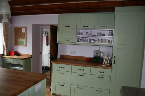 Green Ground wall cupboards with open shelf section.