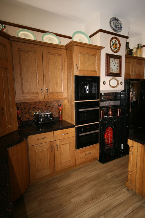 Dark Staron Worktops With Stained Oak Doors